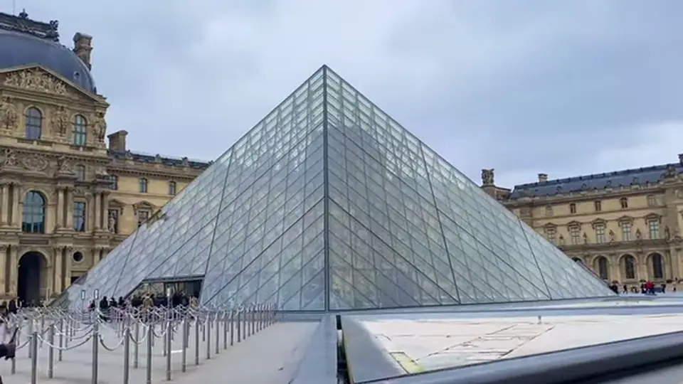 Glass pyramid centered in the Louvre courtyard between palace wings