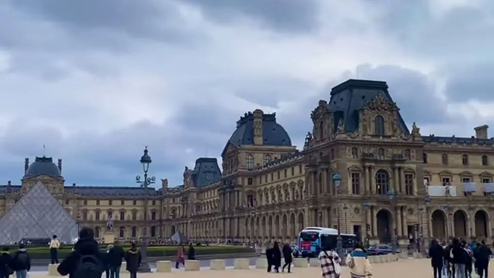 Wide view of the Louvre wing, pyramid and busy forecourt