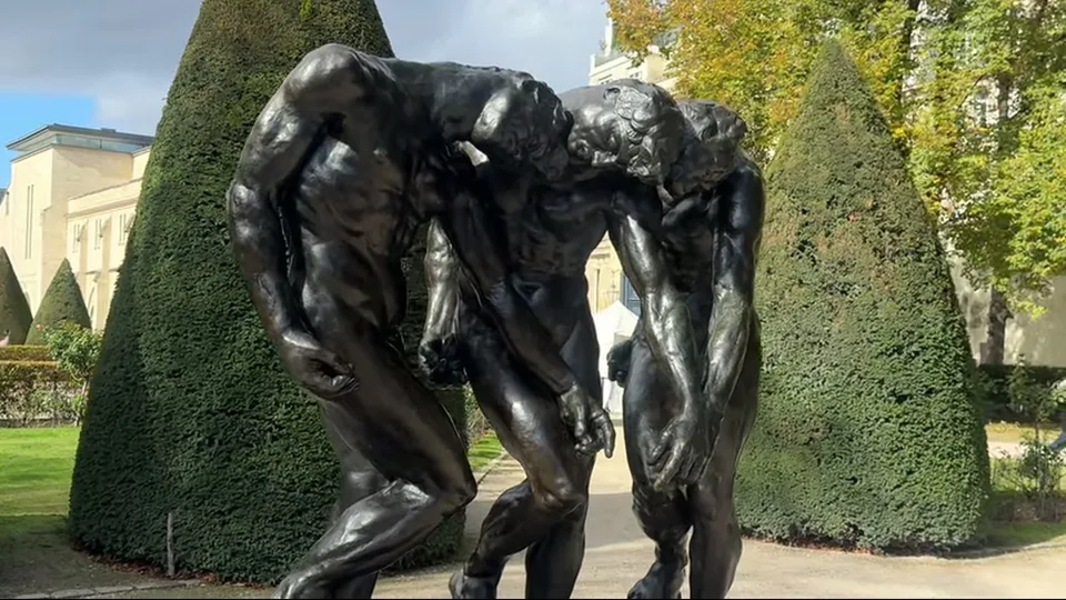 Side view of The Burghers of Calais in the sunlit garden of Musée Rodin