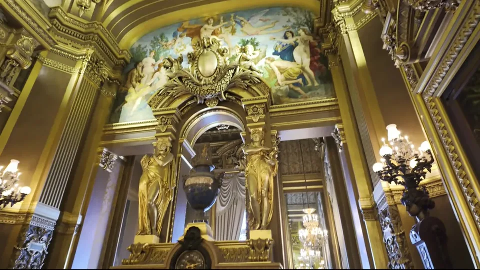 Centered frontal view of Palais Garnier across a busy Paris street